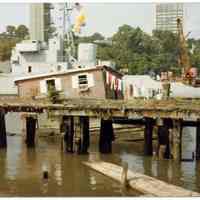 Color photo of houseboat berthed at Hudson River pier, Hoboken, N.J., 1981.