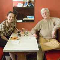 Color photo of 2 people eating in a booth at Schnackenberg