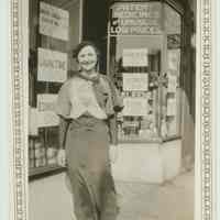 B+W photo of a woman posed in front of the exterior of Baron