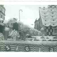 B+W photo of the Tootsie Roll float in Hoboken Centennial celebration parade on Washington St. near 1st St. in Hoboken, 1955.