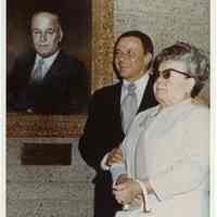 Color photo of Dolly Sinatra with son, Frank Sinatra, in front of painted portrait of Martin Sinatra, n.p. (possibly Cathedral City, CA), n.d., ca. 1969-1970.