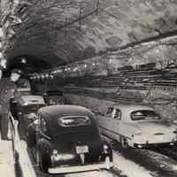 B+W photo of policeman slowing car in Holland Tunnel re-opened after truck explosion, May 15, 1949.