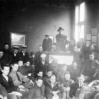 Sepia-tone group photo of men, mostly in military dress, at the Hoboken YMCA, Hoboken, no date, ca. 1918-21.