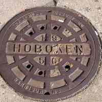 Digital image of cast iron Hoboken manhole cover, location not given., Hoboken, August 8, 2004.