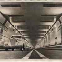 B+W photo of test car inside Lincoln Tunnel just passing the center of a tube, NY-NJ marker, Weehawken, Dec. 18, 1937.