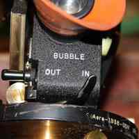          under eyepiece; lever for bubble out - in
   