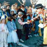 Color photo of the 1985 Hoboken Ragamuffin Parade with Mayor Tom Vezzetti shaking hands with children in costume, Hoboken, October, 1985.