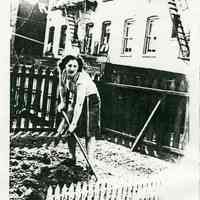 Black-and-white photocopy of photo of Mary Ratti Quattrocchi using a hoe in a World War II Victory Garden behind 721 Adams St., Hoboken, 1943.