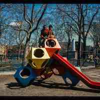          Color slide of eye-level view of children on the playground slide in Church Square Park with swing sets in the background picture number 1
   