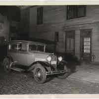 B+W night photos, 2, of Ford automobile parked on street near corner, Hoboken, n.d., probably 1930.