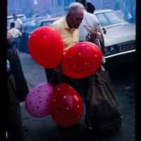 Color slide of a man holding balloons.