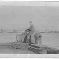 B+W photo of photographer & shipyard employee William Craig sitting at the end of a pier, Hoboken, no date, ca 1940.