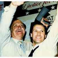 Color photo of mayoral candidate Tom Vezzetti with supporters in front of his campaign headquarters on election night, Hoboken, [June 11, 1985].