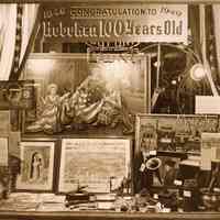 Sepia-tone photo of shop window, Mayflower Paint Products, commemorating a Hoboken centennial, Hoboken, [1949].