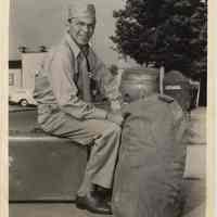 B+W publicity photo of Frank Sinatra in military uniform seated on luggage, no date, circa 1962.