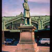 Color slide of eye-level side view of the Sam Sloane statue in front of the Lackawanna Terminal façade