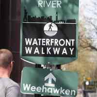          056 Waterfront Walkway sign with arrow showing direction to Weehawken
   