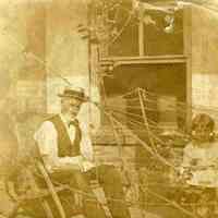 Sepia-tone photo of Madeline Miller, ca. 5 years old, and Grandpa (James Miller?) in the backyard of 716 Bloomfield St., Hoboken, no date, ca. 1890.