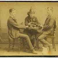 Cabinet photo of 3 firemen posed playing cards in photographer