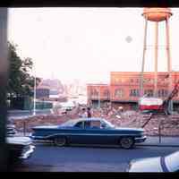 Color slide of a street, water tower and a demolition site.