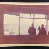 Photo of three people in a building looking north up the Hudson River.