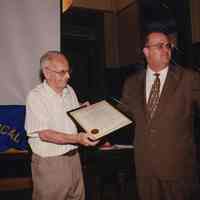 Color photo of Hudson County Freeholder Maurice Fitzgibbons handing a Proclamation to George Kirchgessner, Hoboken City Hall, June 27, 1997.