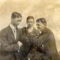 Digital image of photo of three young men in suits in playful fighting pose outdoors, no place, no date, circa 1900-1915.