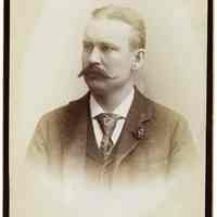 Cabinet photo of a man with mustache posed in photographer