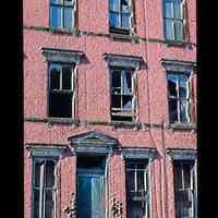 Color slide of a brick building with broken windows.