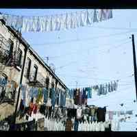 Color slide of laundry hanging from buildings.