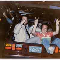 Color photo of two supporters of mayoral candidate Tom Vezzetti sitting in the back of a car on election night, Hoboken, [June 11, 1985].