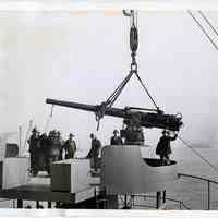 B+W photo of a deck gun being hoisted on to a merchantman ship at Bethlehem Steel Shipyard, Hoboken, Nov. 26, 1941