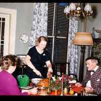 Color slide of Anita Heimbruch and two people at a table.