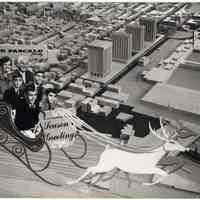 B+W photo postcard of the De Pascale family flying in sleigh over model of Hoboken