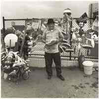 B+W photo of a vendor selling parade souvenir items on River Road approximately 5th or 6th Sts., Hoboken, no date, [1976].