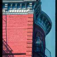 Color slide of detail view of cornice, brackets, quoins, and fire escape at 76 River on the NW corner of River and Hudson Place