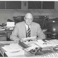 B+W photo of R. Neumann & Co. executive seated at desk, Hoboken, no date, ca. 1950-60.