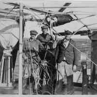 B+W photo of three men at ship