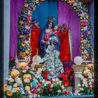 Color slide of a statue of a Madonna with flowers.