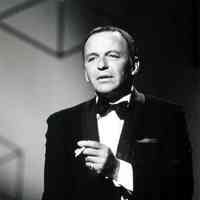 Black-and-white photo of Frank Sinatra in tuxedo on stage with cigarette, no place, no date, ca. 1965.