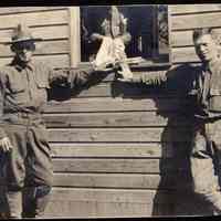 Digital image of photo of two uniformed men outside a military barracks or other base building, no place, no date, circa 1900-1910.