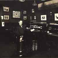 Digital image of a sepia-tone photo of John Muller seated in his insurance office, Hoboken, no date, ca. 1920