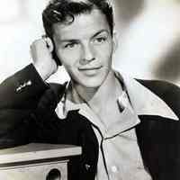 Black-and-white publicity photo of a young Frank Sinatra in a dark jacket & small check shirt with open neck, no place, no date, ca. 1940-45.