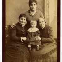 Cabinet photo of 3 women & a baby (4 generations) posed in photographer