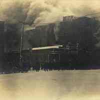 Sepia-tone photo of exterior view of a fire, Clinton & Eighth Sts. corner of John Schmalz