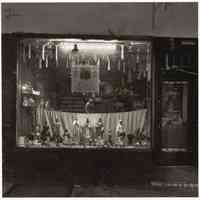 B+W photo of a night view of the window of Botanica Santa Marta store, street number 302, street not named, Hoboken, no date, [1976].