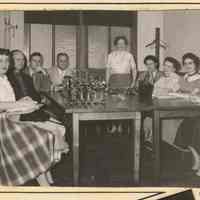          1, left column, top: group seated at table, bowling trophies on table
   