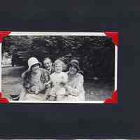          37: two woman, man and large baby posed outdoors
   