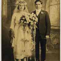 Sepia-tone photo of wedding couple posed in studio with church interior backdrop, Hoboken, n.d., ca. 1910-1920.