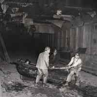 B+W photo of 3 sandhogs moving rowboat inside third tube of Lincoln Tunnel, Jan. 25, 1956.